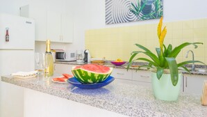 Eine Küche mit einer Arbeitsplatte aus Granit, einer Mikrowelle, einem Spülbecken und einem Blumentopf.