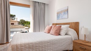 A bedroom with a bed, a nightstand, a lamp, and a view of the outside. - VILLA ISABEL - Great holiday home with several terraces near the beach. Free WiFi (Muro)