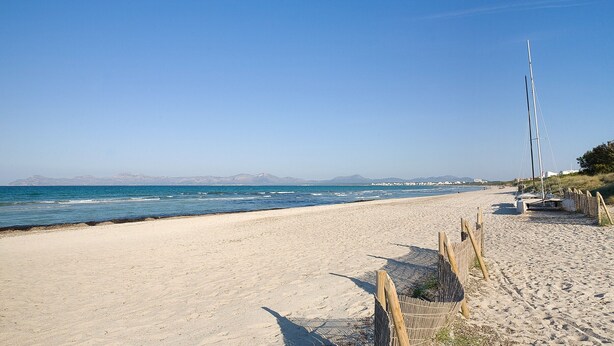 A beach with a clear sky, calm sea, and a sailboat docked on the right. - VILLA ISABEL - Great holiday home with several terraces near the beach. Free WiFi (Muro)
