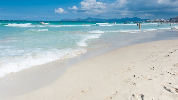 A beach with clear turquoise water, a sandy shore, and distant mountains. - CAN BARRET - Chalet for 6 people in Ca'n Picafort. Free WiFi (Ca��n Picafort)