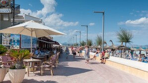 A seaside promenade with outdoor seating, umbrellas, and a view of the beach. - CAN BARRET - Chalet for 6 people in Ca'n Picafort. Free WiFi (Ca��n Picafort)