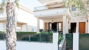 A two-story house with a balcony, a staircase, and a palm tree. - CAN BARRET - Chalet for 6 people in Ca'n Picafort. Free WiFi (Ca��n Picafort)