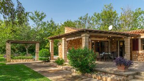 A covered patio area with stone columns, a pergola, and a dining table with chairs. - SES TENDES - Villa with private pool and beautiful garden. Free WIFI (Algaida)