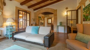 A spacious living area with a sofa, armchairs, and a dining table. - SES TENDES - Villa with private pool and beautiful garden. Free WIFI (Algaida)