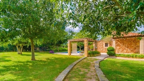 A stone building with a stone facade and a pergola in the garden. - SES TENDES - Villa with private pool and beautiful garden. Free WIFI (Algaida)