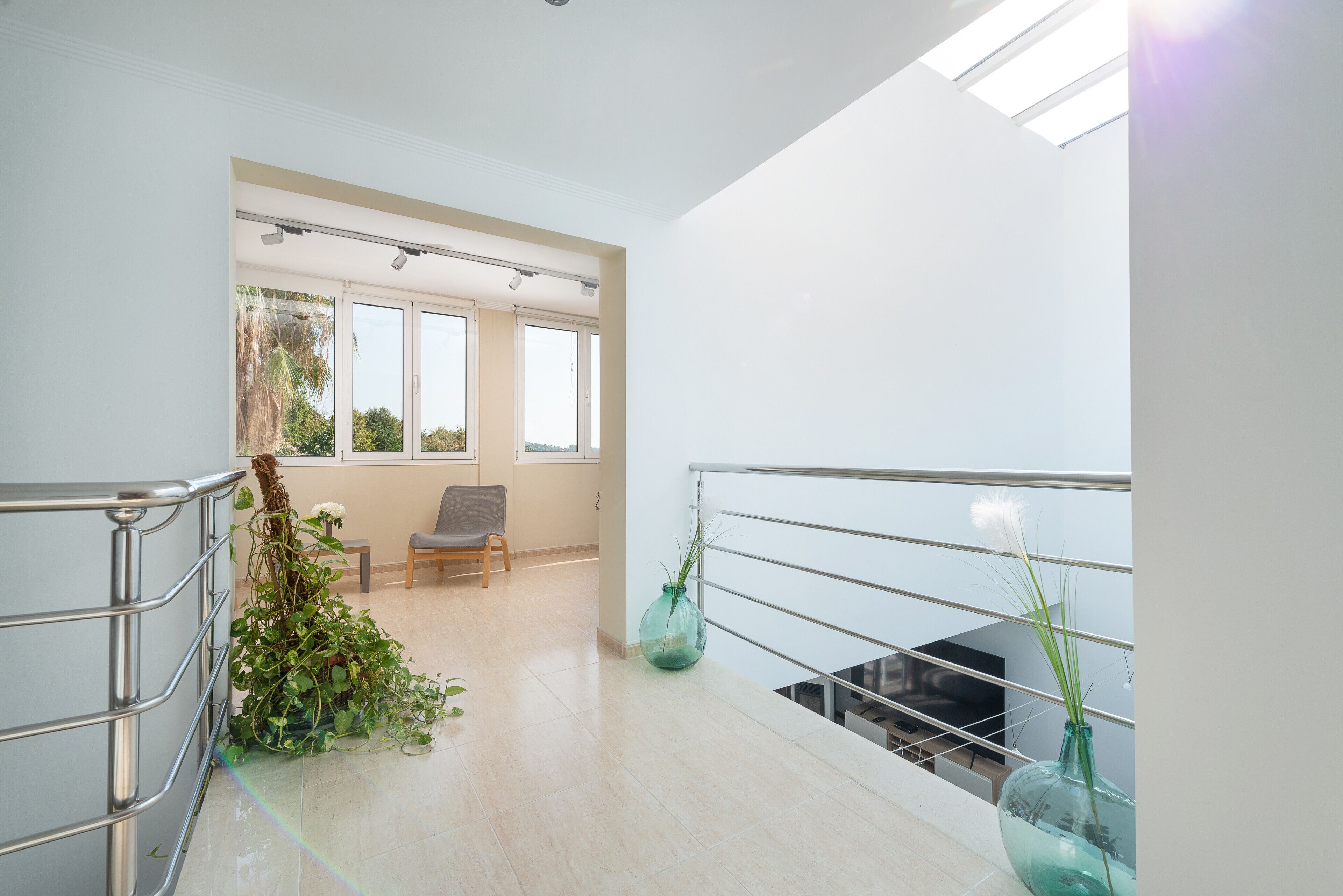 A spacious, well-lit room with a balcony, large windows, and a view of the outdoors.