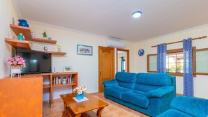 Ein Wohnzimmer mit einer Couch, einem Couchtisch und einem Fernsehschrank.