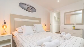 Ein Hotelzimmer mit einem großen Bett, zwei Nachttischen, einem an der Wand befestigten Spiegel und einer Deckenleuchte.