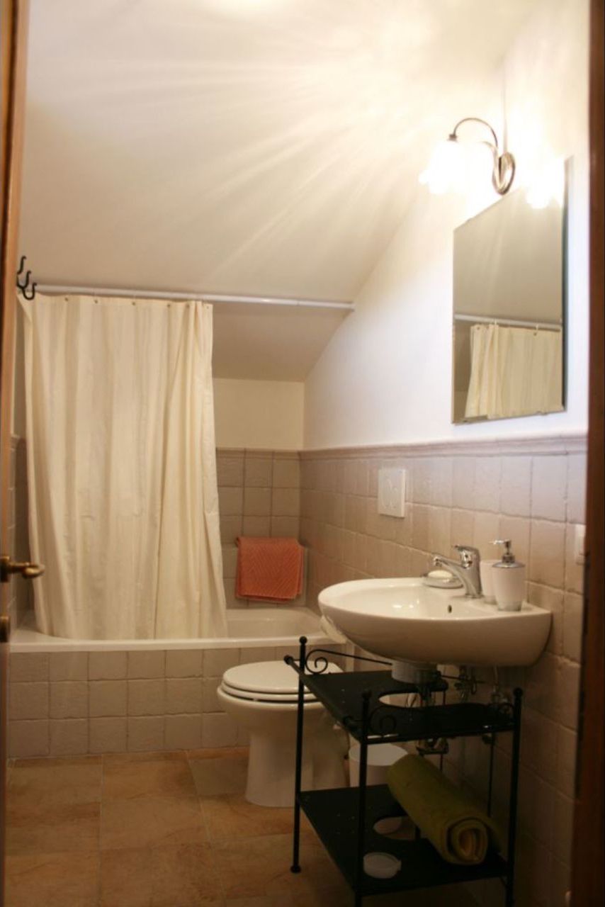 Baño con bañera, inodoro, lavabo y toallero.