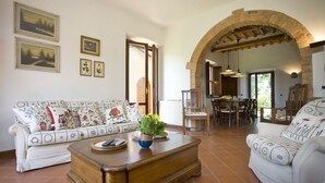 A spacious living room with a sofa, a coffee table, and a dining area with a table and chairs.