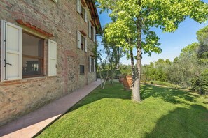 A stone building with a paved pathway and a well-maintained lawn.