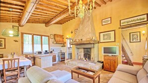 A spacious living room with a fireplace, comfortable seating, and a kitchen area with modern appliances. - Stunning private villa with private pool, WIFI, TV, patio and panoramic view, close to San Gimig... (Sciano)
