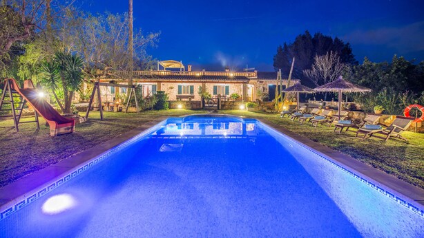 A swimming pool with a clear blue water surface, surrounded by lounge chairs and umbrellas, with a building in the background. - CA SA NINA - Villa with private pool in Inca. Free WiFi (Inca)