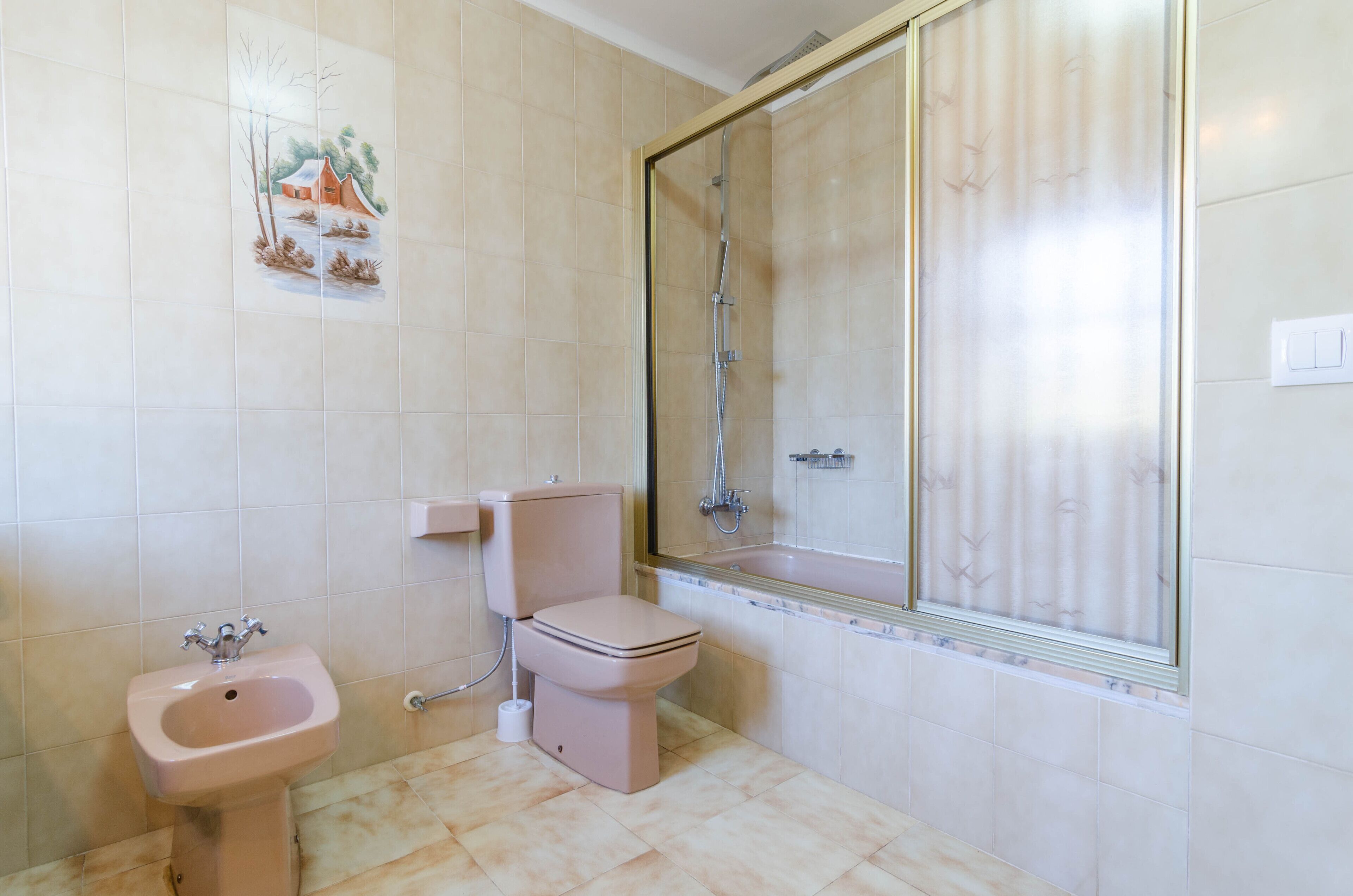 A bathroom with a toilet, sink, and shower.