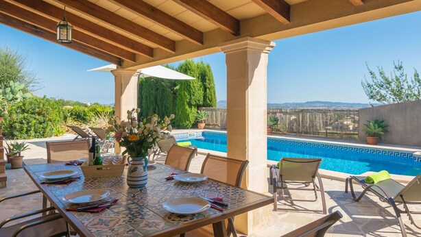 An outdoor patio with a pool, wooden beams, and a table set for dining. - PLETA DE BONANY - Villa with private pool in Vilafranca De Bonany. Free WiFi (Vilafranca de Bonany)