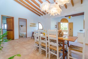 A dining area with a wooden table and white chairs, a wooden ceiling with exposed beams, and a sign reading "TORRE MARINA".