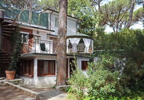 A two-story house with a balcony, a staircase, and a garden. - Cosy apartment for 3 people with WIFI and TV (Marina Di Castagneto Carducci)