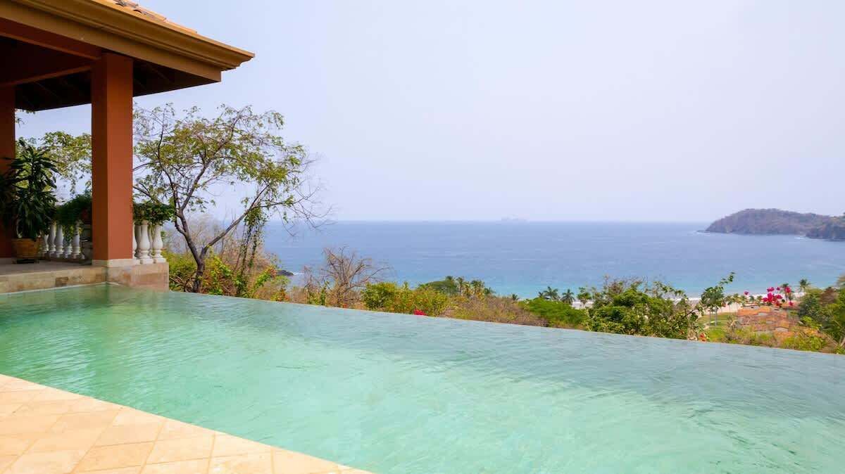 Vista despejada de una piscina con vistas al océano y una isla distante.