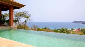 A clear view of a swimming pool with a view of the ocean and a distant island.
