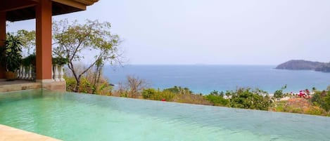 Vista despejada de una piscina con vistas al océano y una isla distante.