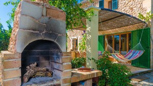 A stone-built outdoor kitchen with a brick oven, a hammock, and a thatched roof. - SA MATA - Spectacular Majorcan finca with private pool enclosed by the trees and greenery (Campanet)