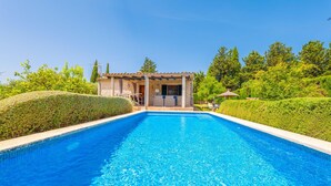 Une piscine avec un bâtiment en pierre en arrière-plan.