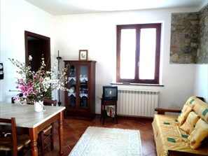 Relax in this traditional living room with a dining table, sofa, and television.