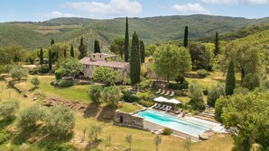 A villa with a swimming pool, surrounded by lush greenery and hills. - Private Villa with WIFI, hot tub, private pool, TV, patio, panoramic view, close to Greve In Chianti (Lucarelli)