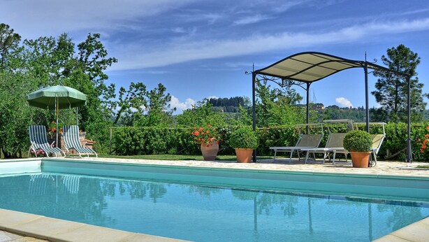A swimming pool with lounge chairs and umbrellas, surrounded by greenery and a clear sky. - Wonderful private villa for 8 people with private pool, A/C, WIFI, TV, terrace and panoramic view (Corazzano)