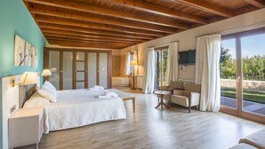 A spacious room with a large bed, a sofa, a TV, and a view of the outdoors. - FINCA S'HORT DE CONIES - Spectacular house with private pool surrounded by fields and peac (Manacor)
