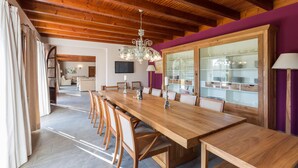 A spacious dining area with a long wooden table and chairs, a chandelier, and a glass cabinet with dishes. - FINCA S'HORT DE CONIES - Spectacular house with private pool surrounded by fields and peac (Manacor)