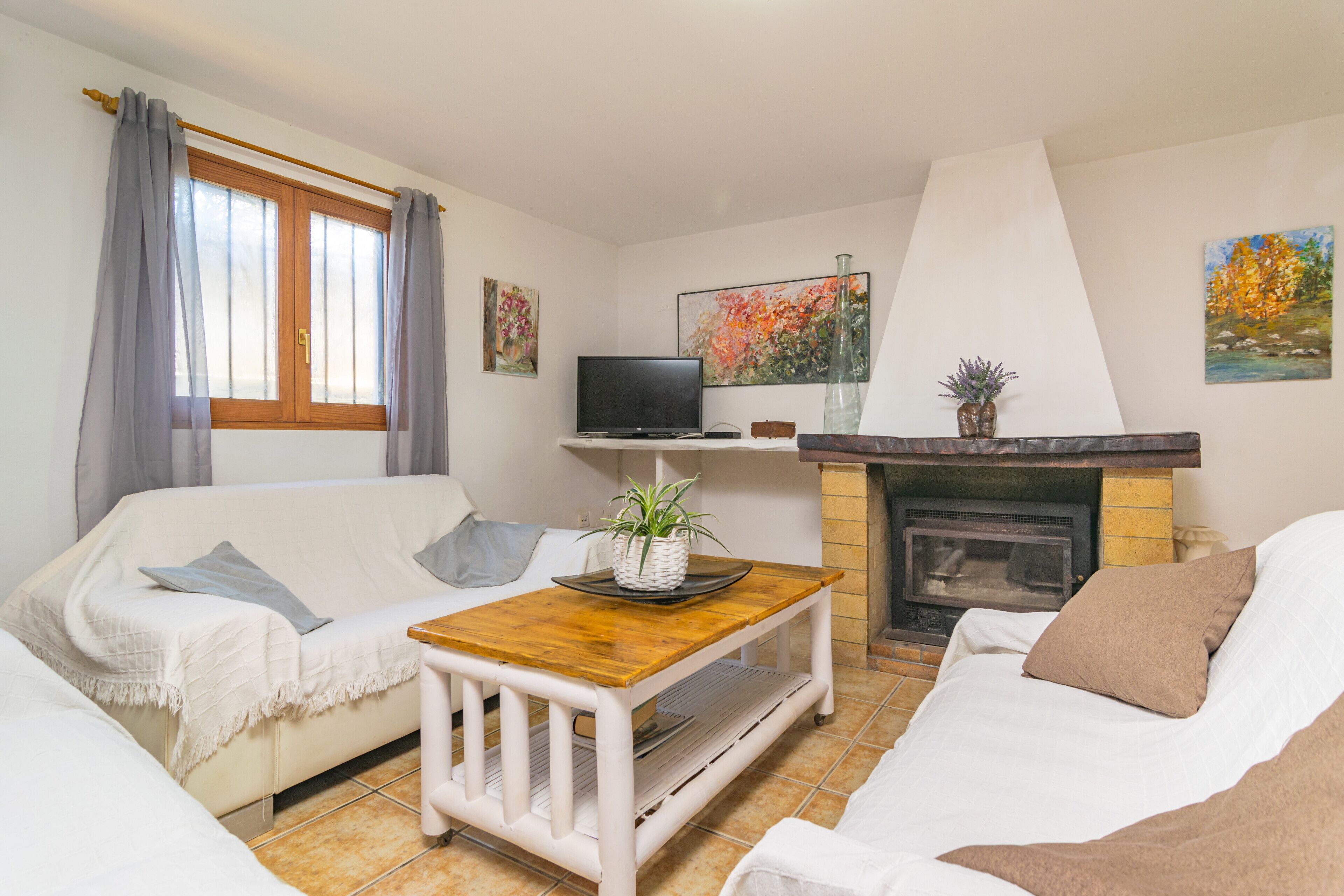 Ein Wohnzimmer mit einer Couch, einem Couchtisch, einem Kamin und einem Fernseher.
