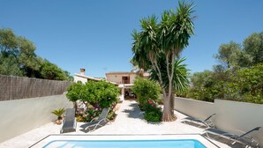 A pool area with lounge chairs, a palm tree, and a building in the background. - WOODHOUSE - Beautiful townhouse with private pool, porch with BBQ and wonderful terrace. F (Ariany)