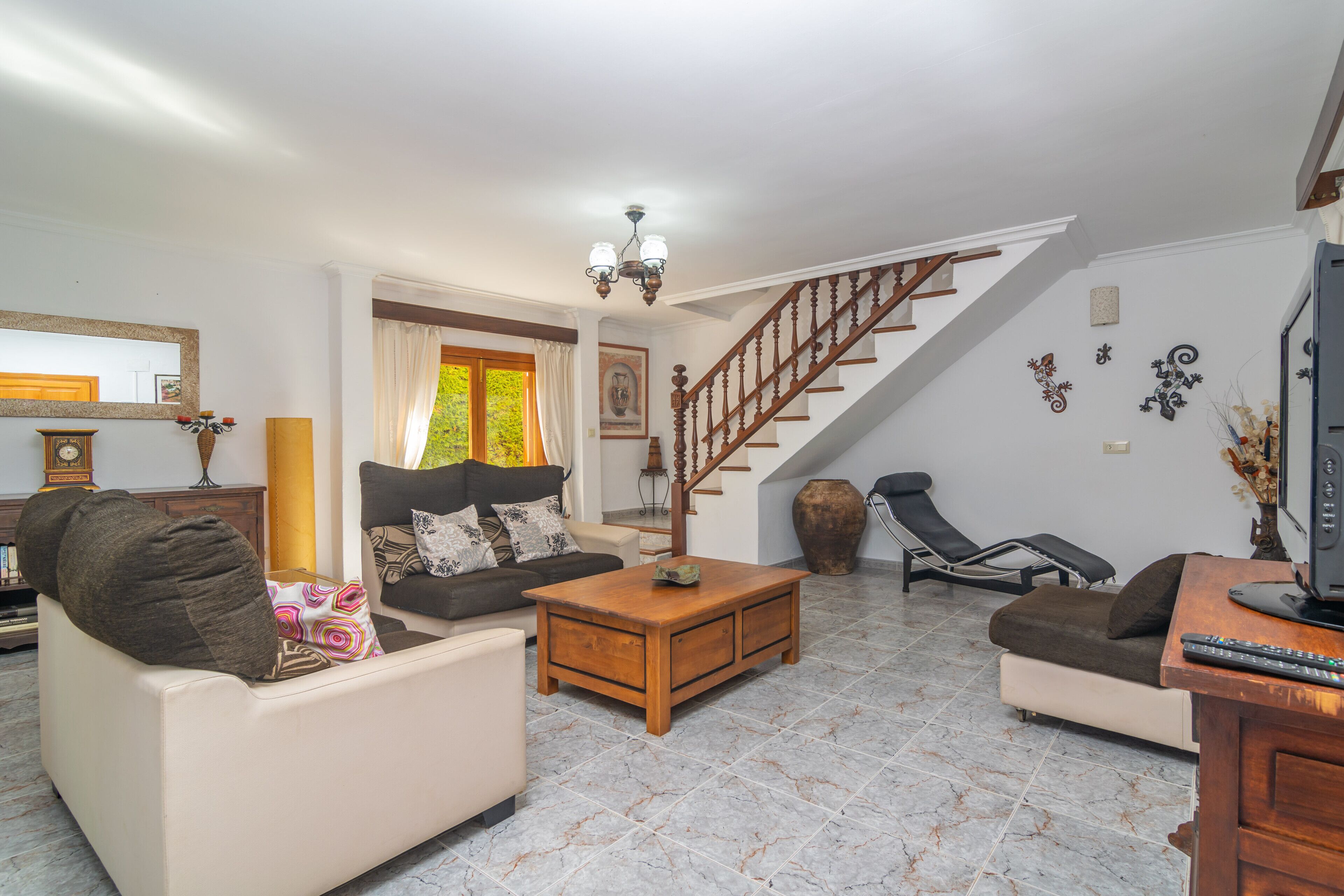 A living room with a sofa, coffee table, and a staircase.