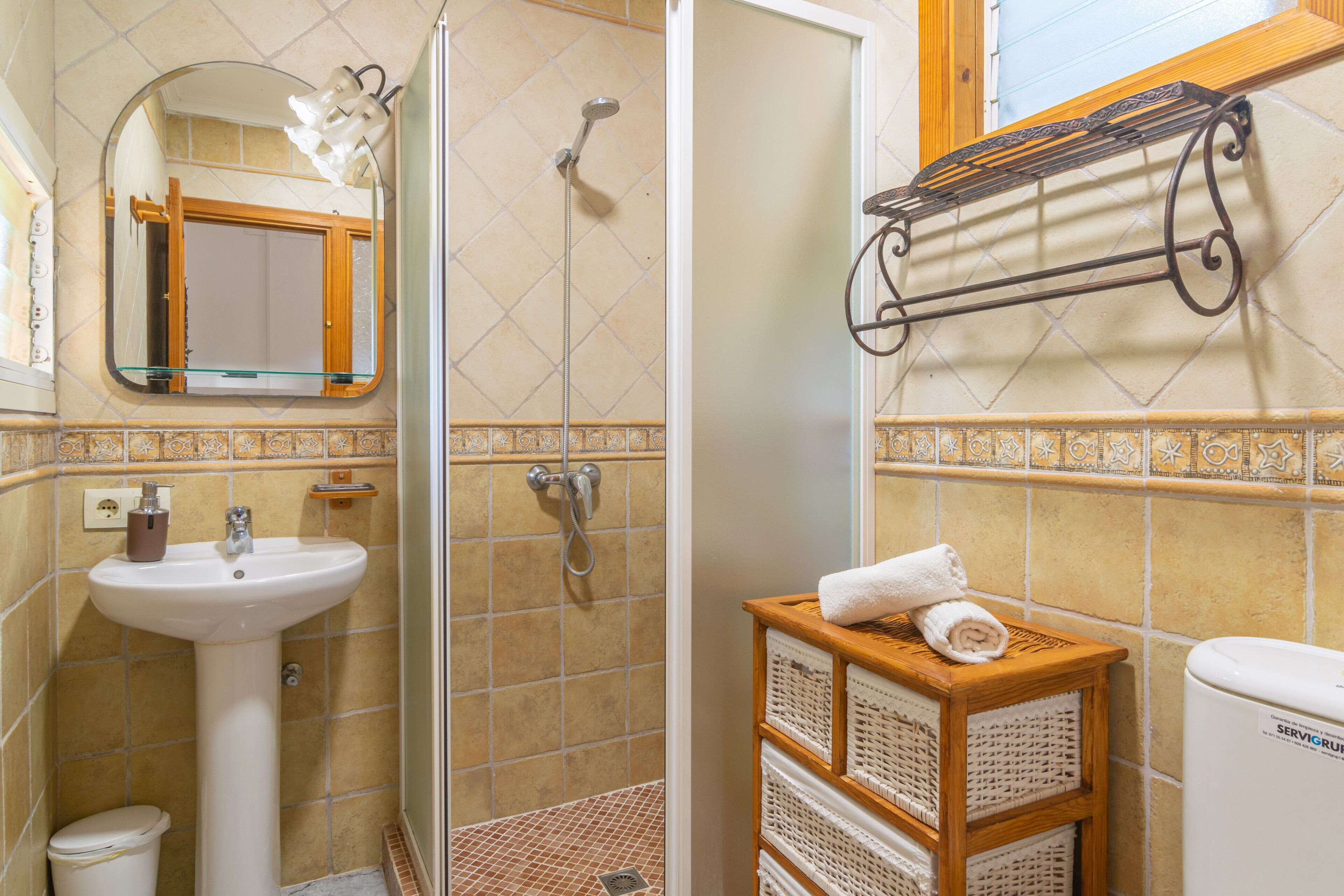 A bathroom with a shower, sink, and a towel rack.
