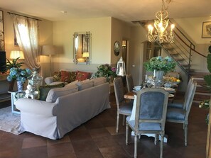 A living room with a sofa, dining table, chairs, and a chandelier. - Beautiful private villa for 7 people with WIFI, private pool, A/C, TV, patio and panoramic view (Fabbrica)