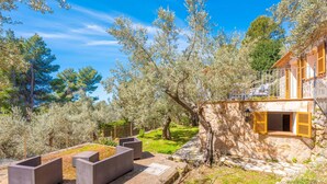 A stone building with outdoor seating, a stone pathway, and trees.