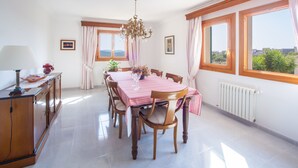 A dining area with a table set for six, surrounded by wooden chairs. - VILLA BELLAVISTA – Villa with private pool in Campanet with free WiFi (Campanet)