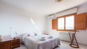 A bedroom with a bed, wooden dresser, and a radiator. - VILLA BELLAVISTA – Villa with private pool in Campanet with free WiFi (Campanet)