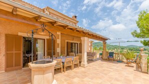 A covered patio with a stone fountain, outdoor seating, and a view of the countryside. - ES TURO DE FRANÇA - Villa with private pool in S'Horta. Free WiFi (Felanitx)