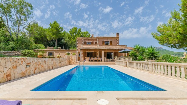 A swimming pool with a stone wall and lounge chairs, surrounded by a stone fence and trees. - ES TURO DE FRANÇA - Villa with private pool in S'Horta. Free WiFi (Felanitx)