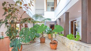 A spacious indoor area with multiple potted plants, a stone wall, and a high ceiling. - TURIXANT DALT - Villa with private pool in Mancor De La Vall. Free WiFi (Mancor de la Vall)