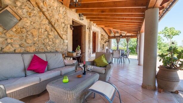 A covered outdoor seating area with stone walls, wicker furniture, and a potted plant. - FINCA CAN DIEGO - Villa with private pool in Inca. Free WiFi (Inca)