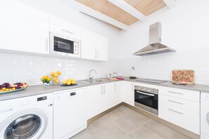 A modern kitchen with white cabinetry, a built-in oven, a microwave, and a washing machine. - CAN DIANA - Vacation home with private pool in peaceful town. Free WiFi (Campanet)