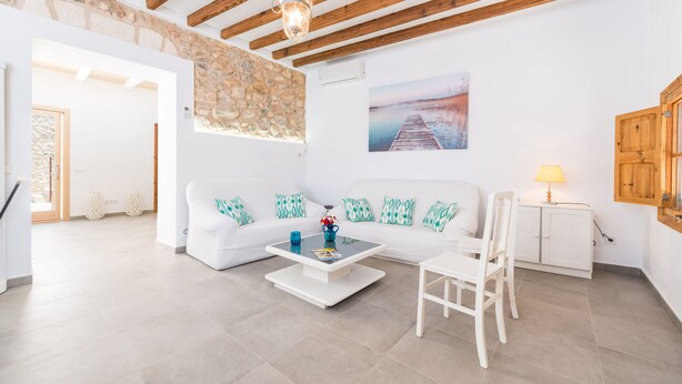 A spacious living room with a white sofa, a coffee table, and a wooden cabinet. - CAN DIANA - Vacation home with private pool in peaceful town. Free WiFi (Campanet)