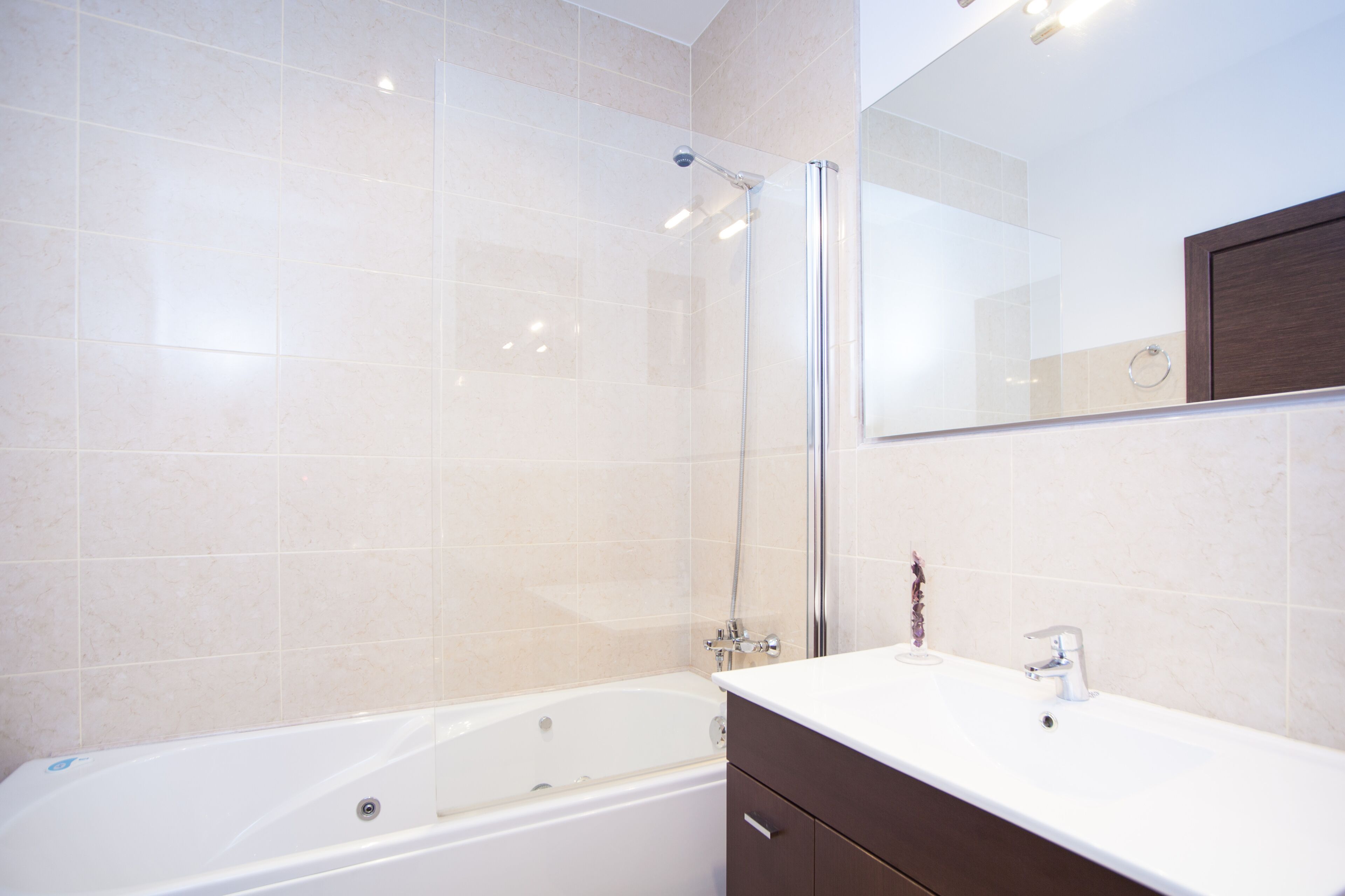 Un baño moderno con bañera, ducha y tocador con espejo.