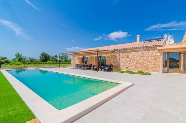 Una piscina con un edificio de piedra al fondo.