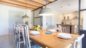 A dining area with a wooden table set for six, surrounded by white chairs with patterned cushions. - FINCA CAN POL - Villa with private pool in Inca. Free WiFi (inca)