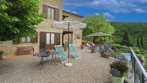 A stone building with a patio area featuring a table, chairs, and an umbrella.