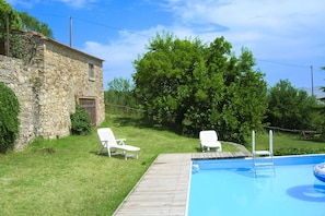 A swimming pool with two white lounge chairs and a stone building in the background. - Stunning private villa with WIFI, private pool, veranda and pets allowed, close to Arezzo (Capolona)